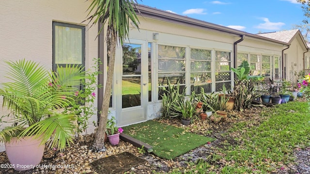 view of property exterior featuring stucco siding and a sunroom