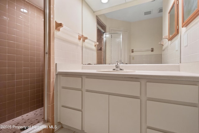 bathroom with visible vents, backsplash, a stall shower, and vanity