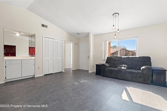 living area with visible vents, baseboards, a textured ceiling, and vaulted ceiling