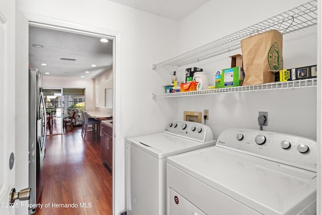 washroom with dark wood-type flooring, a textured ceiling, recessed lighting, laundry area, and washing machine and clothes dryer