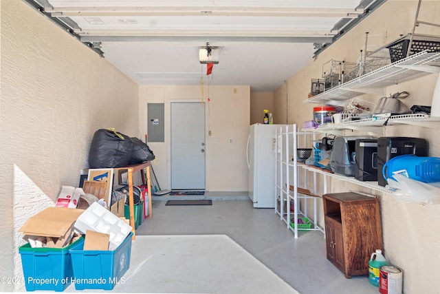 garage with electric panel, a textured wall, a garage door opener, and freestanding refrigerator