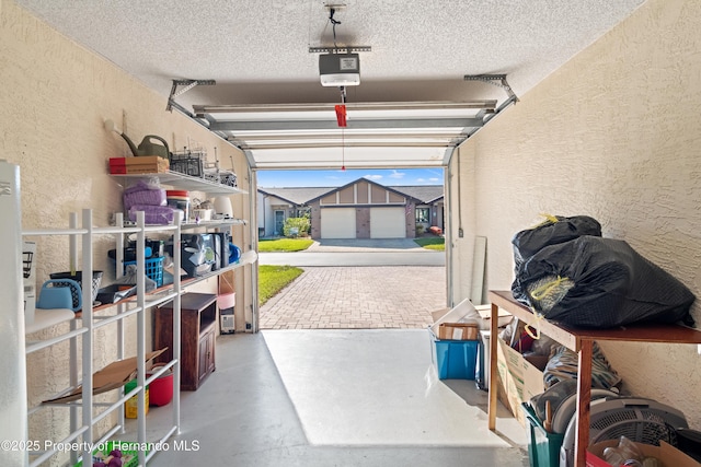 garage with a garage door opener and a textured wall