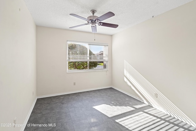 empty room with baseboards, tile patterned flooring, a textured ceiling, and ceiling fan