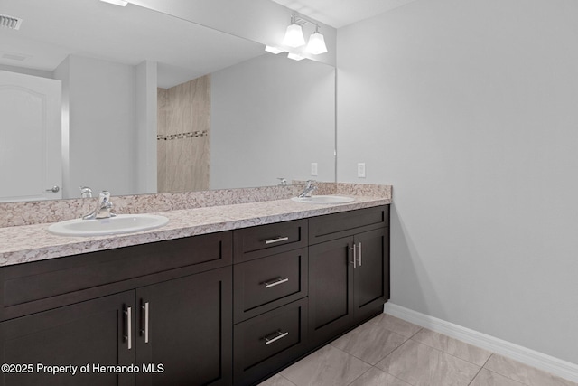 bathroom featuring a sink, visible vents, baseboards, and double vanity