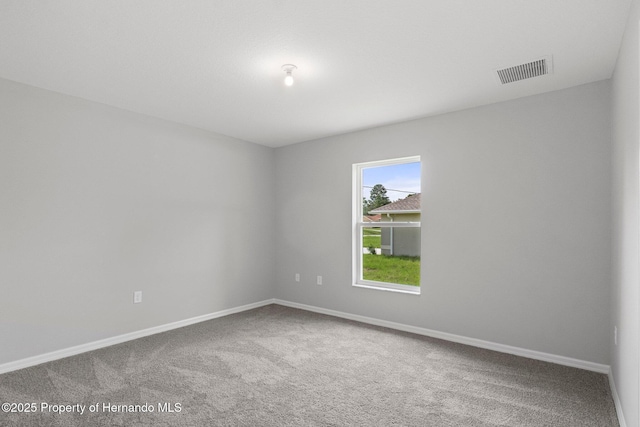 unfurnished room with visible vents, carpet floors, and baseboards