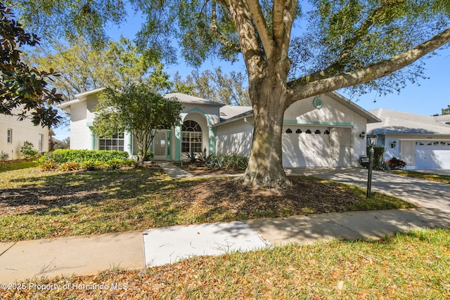 view of front of property featuring an attached garage, brick siding, and driveway