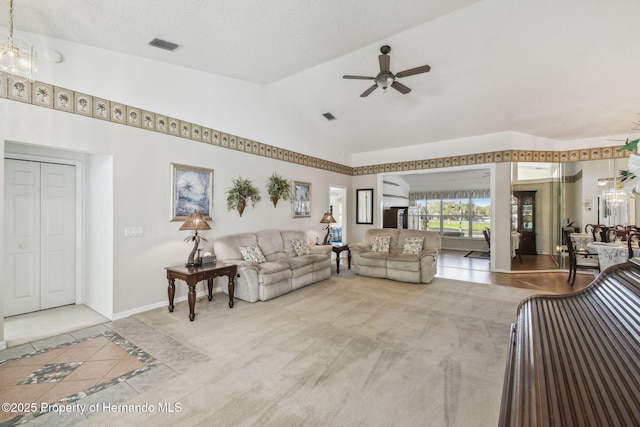 carpeted living room with visible vents, baseboards, a ceiling fan, and vaulted ceiling