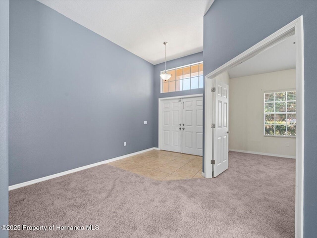 carpeted entrance foyer with tile patterned floors and baseboards