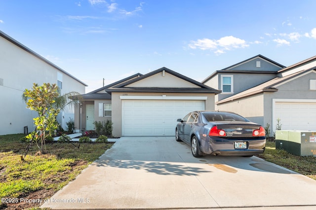 view of front of house with stucco siding, driveway, and a garage