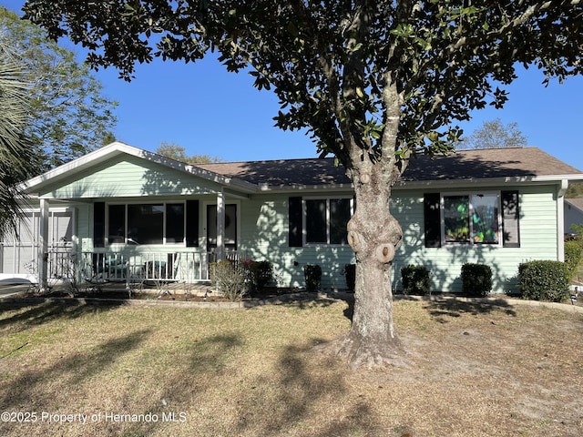 ranch-style home with a porch and a shingled roof