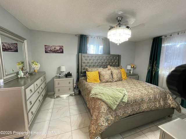 bedroom with a textured ceiling and marble finish floor