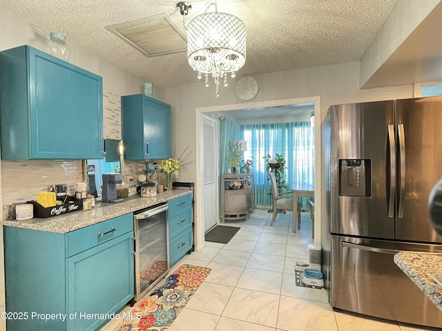 kitchen with tasteful backsplash, blue cabinetry, wine cooler, stainless steel fridge, and marble finish floor