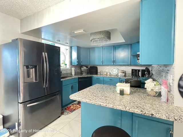 kitchen with dishwasher, decorative backsplash, blue cabinetry, and stainless steel fridge with ice dispenser