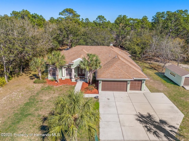 view of front of property with stucco siding, driveway, a front yard, and a garage