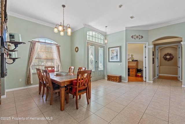 dining area featuring light tile patterned floors, baseboards, arched walkways, french doors, and crown molding