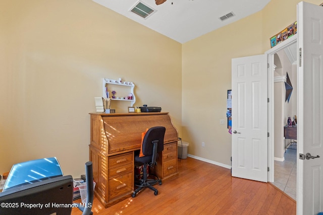 office area with visible vents, baseboards, light wood-style flooring, and a ceiling fan