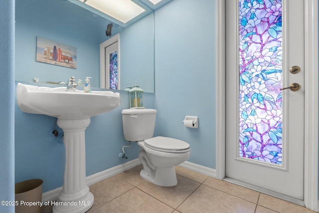 bathroom with tile patterned floors, toilet, and baseboards