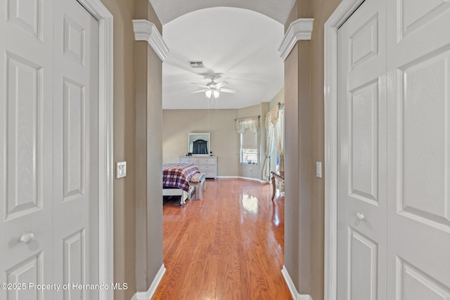 hallway with light wood-type flooring, baseboards, and visible vents