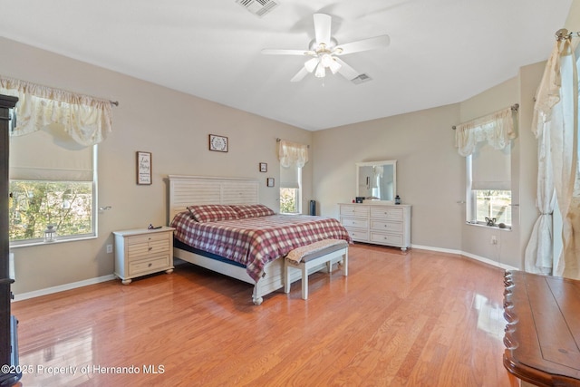 bedroom with baseboards, visible vents, and light wood finished floors