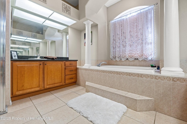 full bathroom with decorative columns, a garden tub, vanity, and tile patterned flooring