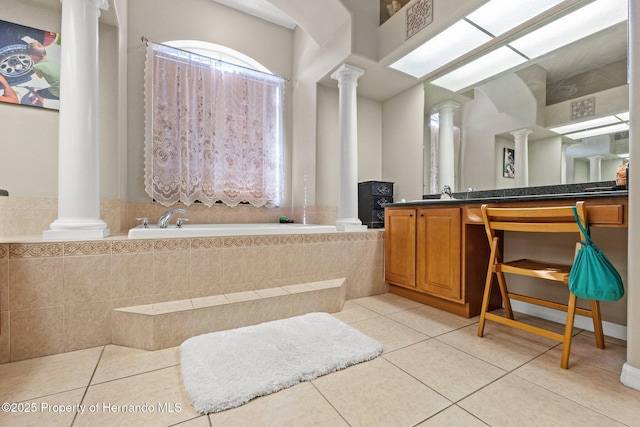 full bath featuring vanity, tile patterned floors, a garden tub, and ornate columns