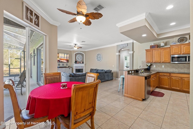 dining room with ornamental molding, light tile patterned floors, visible vents, and ceiling fan