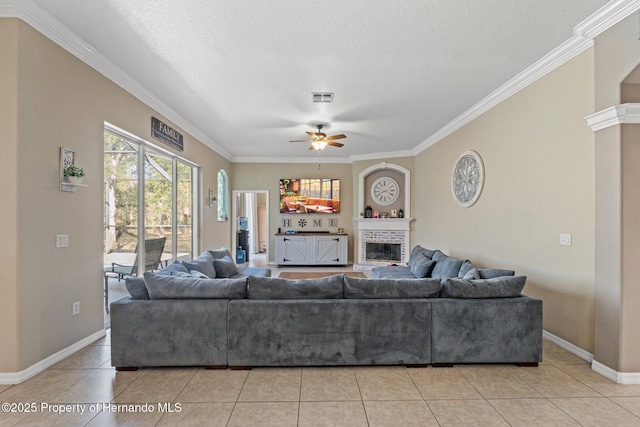 living area featuring visible vents, a ceiling fan, a textured ceiling, light tile patterned flooring, and a fireplace