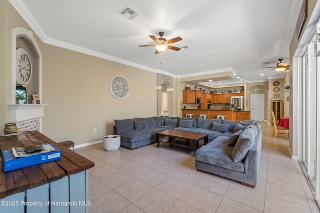 living room featuring ornamental molding, visible vents, light tile patterned floors, and ceiling fan