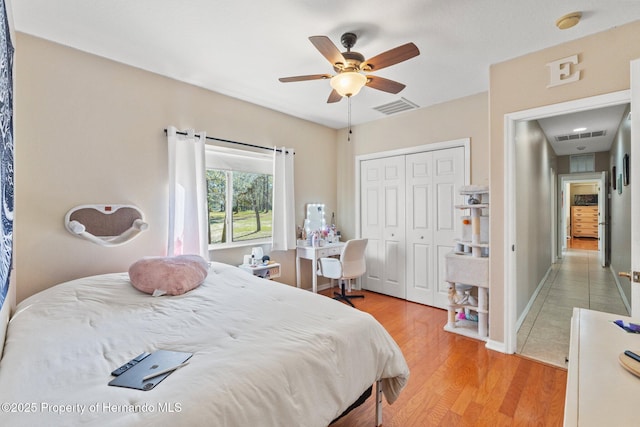 bedroom with a closet, visible vents, baseboards, and light wood-style floors