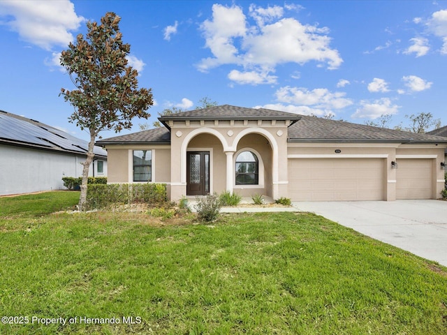 mediterranean / spanish house featuring stucco siding, driveway, a front lawn, and an attached garage