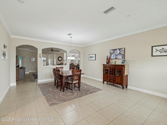 dining area with visible vents, arched walkways, light tile patterned flooring, crown molding, and baseboards