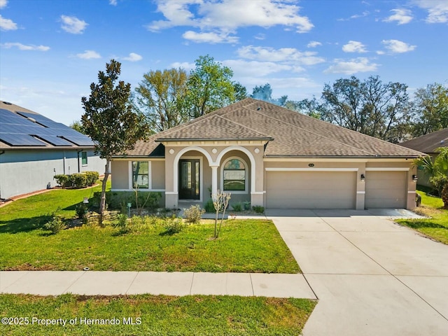 view of front facade featuring a front yard, a garage, driveway, and stucco siding