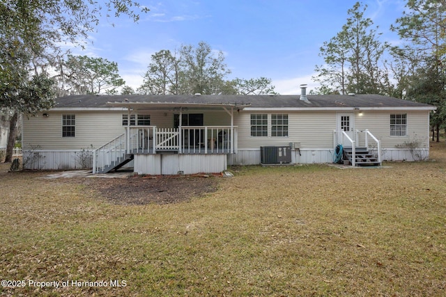 rear view of property with cooling unit and a yard