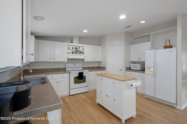 kitchen with a sink, open shelves, a kitchen island, white appliances, and white cabinets
