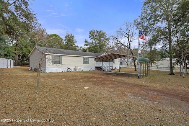 view of front facade with a carport, a storage shed, and an outdoor structure
