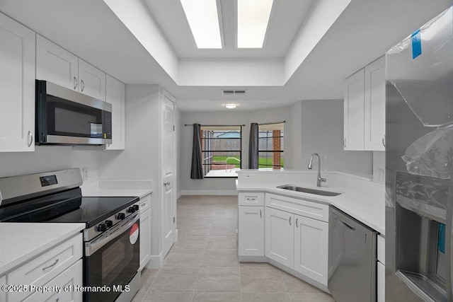 11080 Marquette St, Spring Hill, FL 34609 - kitchen with light tile patterned floors, light countertops, visible vents, a tray ceiling, and stainless steel appliances