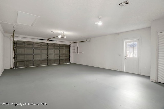 11080 Marquette St, Spring Hill, FL 34609 - garage featuring electric panel, visible vents, and a garage door opener