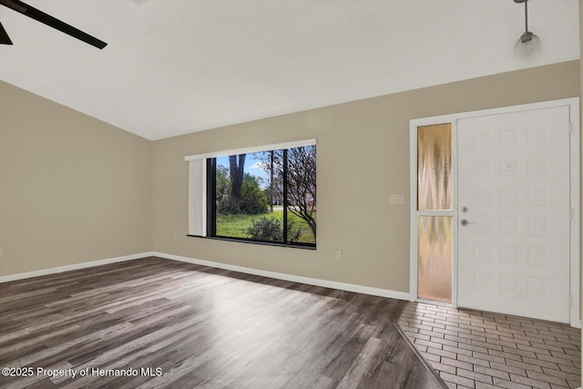 interior space featuring vaulted ceiling, baseboards, and dark wood-style flooring