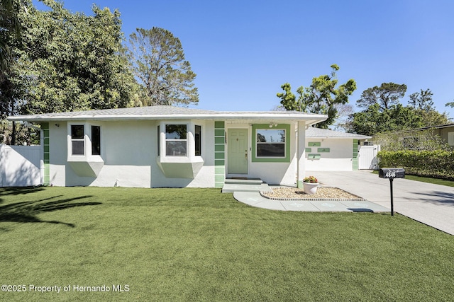 single story home featuring stucco siding, driveway, fence, and a front lawn
