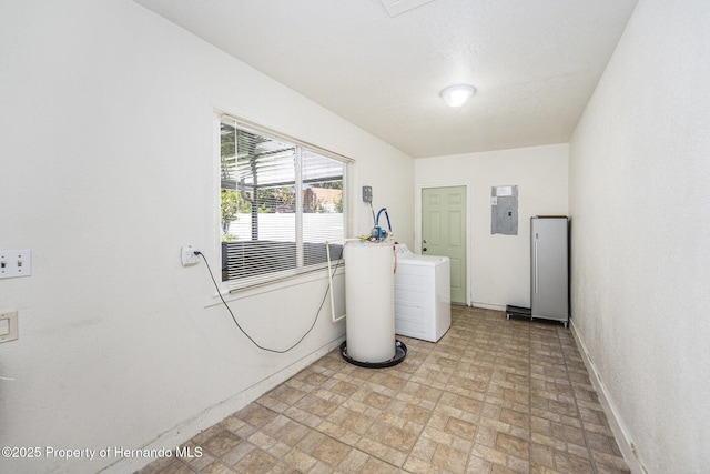 laundry room featuring baseboards, laundry area, electric panel, and washer / dryer