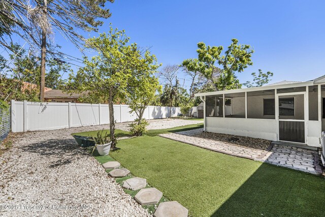 view of yard with a fenced backyard and a sunroom