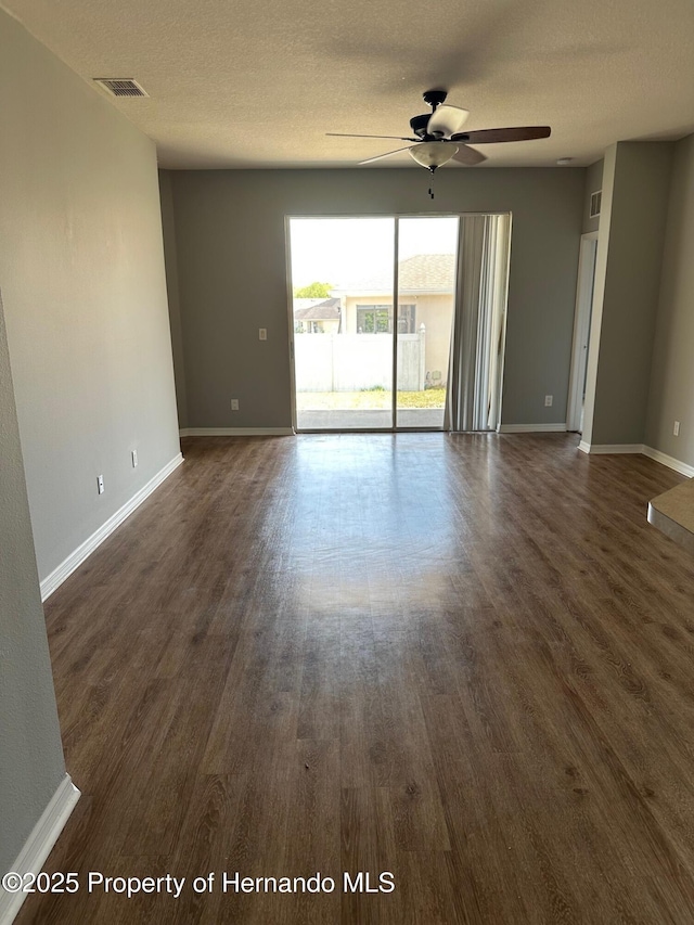 8480 Southern Charm Cir, Brooksville, FL 34613 - spare room featuring baseboards, dark wood finished floors, a textured ceiling, ceiling fan, and visible vents
