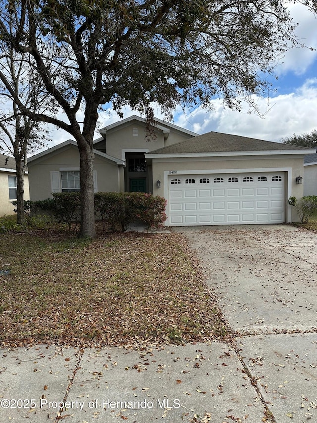 8480 Southern Charm Cir, Brooksville, FL 34613 - single story home featuring a shingled roof, driveway, stucco siding, and a garage