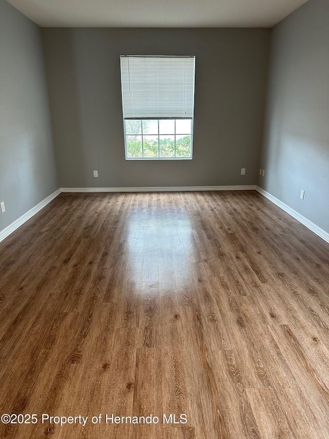 8480 Southern Charm Cir, Brooksville, FL 34613 - unfurnished room featuring dark wood-style flooring and baseboards