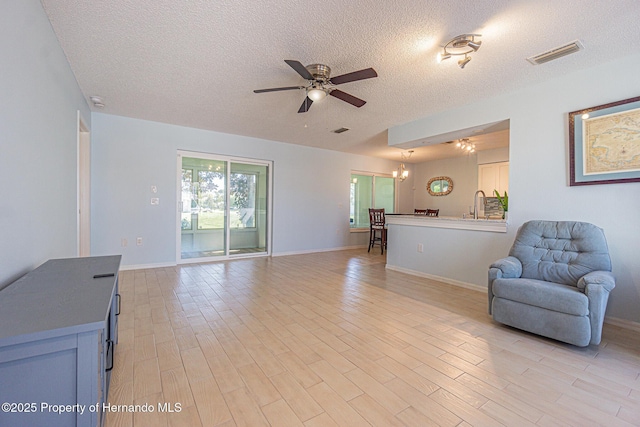18836 Summersong Dr, Hudson, FL 34667 - living area featuring visible vents, ceiling fan, a textured ceiling, and light wood finished floors