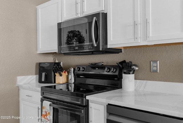 1018 Stratton Ave, Spring Hill, FL 34609 - kitchen with white cabinets, light stone countertops, and stainless steel appliances