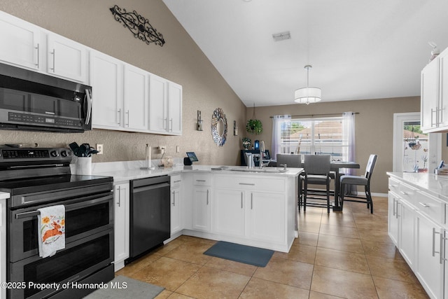 1018 Stratton Ave, Spring Hill, FL 34609 - kitchen featuring white cabinetry, dishwashing machine, light tile patterned floors, range with two ovens, and a peninsula