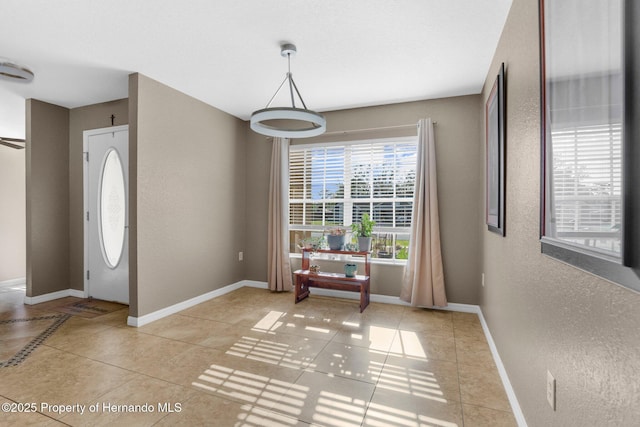 1018 Stratton Ave, Spring Hill, FL 34609 - foyer with light tile patterned flooring, baseboards, and a textured wall