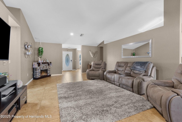 1018 Stratton Ave, Spring Hill, FL 34609 - living area featuring light tile patterned flooring, visible vents, baseboards, a fireplace, and lofted ceiling