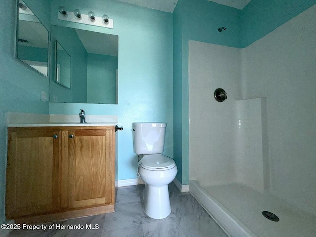 bathroom featuring toilet, a shower, vanity, marble finish floor, and baseboards